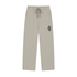 A pair of light beige drawstring sweatpants with a small colorful graphic patch on the left hip, displayed against a solid white background.