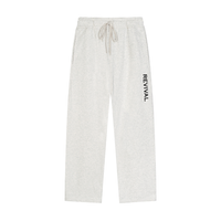Light heather gray sweatpants with a drawstring waist and a vertical black 'REVIVAL' logo on the left leg, shown against a plain white background.