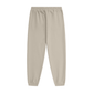 A pair of light beige jogger pants with an elastic waistband and ribbed ankle cuffs, shown flat against a solid white background.