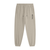 Beige tapered jogger pants with an elastic drawstring waistband, side pockets, elastic cuffs, and vertical black REVIVAL lettering on the upper thigh.

