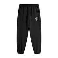 Black tapered jogger pants with a drawstring waist, side pockets, elastic cuffs, and a small white monogram logo on the upper thigh.