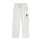 Light heather gray sweatpants with an elastic drawstring waist and a small green circular patch on the left thigh, shown against a plain white background.