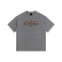 A gray short-sleeve t-shirt with a distressed metallic bronze graphic on the chest reading &
