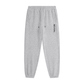 Gray tapered jogger pants with an elastic drawstring waistband, side pockets, elastic cuffs, and vertical black REVIVAL lettering on the upper thigh. 
