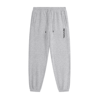 Gray tapered jogger pants with an elastic drawstring waistband, side pockets, elastic cuffs, and vertical black REVIVAL lettering on the upper thigh. 